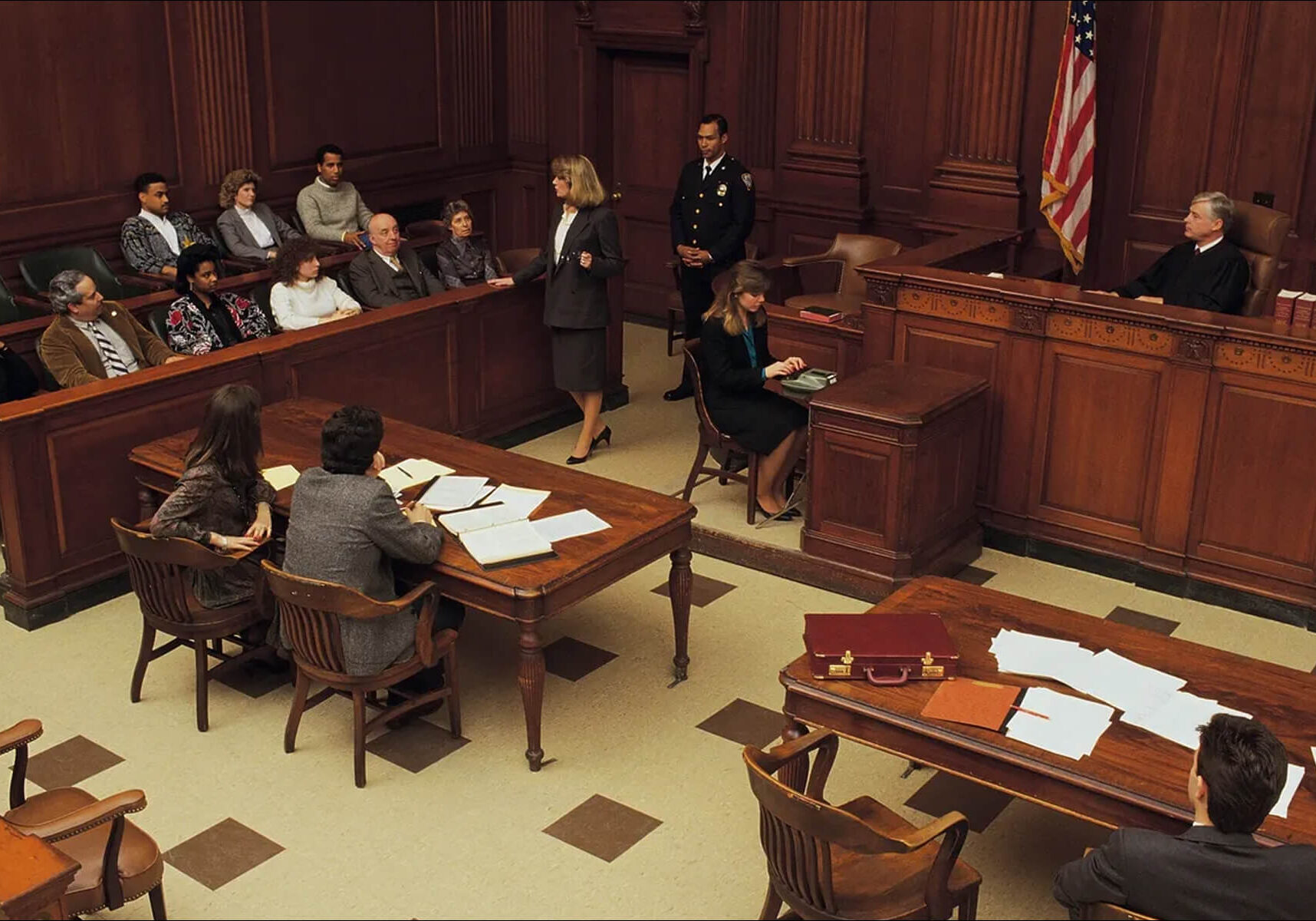 Courtroom scene with judge, jury, and lawyers.